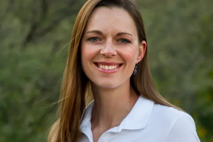 Crystal Blaker, Ruff House lead dog trainer, smiling outdoors